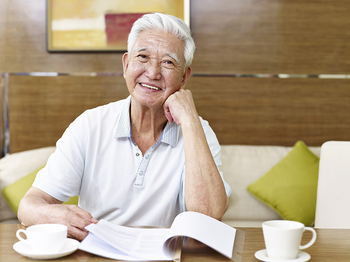 shutterstock_533984515 Elderly man sitting at a table.